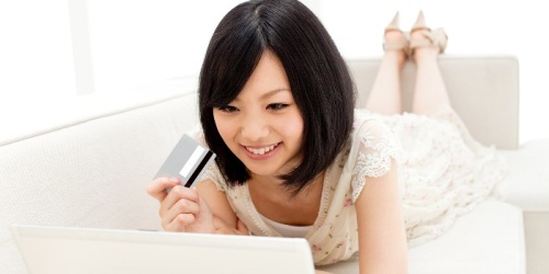 Beautiful young woman using a laptop computer. Portrait of asian.